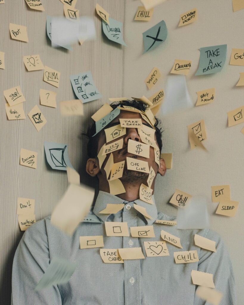 Person with many sticky notes covering their face and upper body, each note filled with to-do reminders, creating a chaotic, overwhelmed scene.