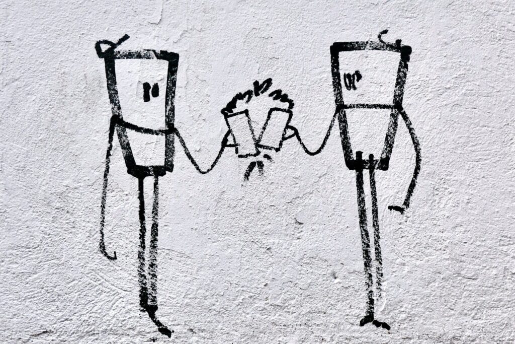 Two stick figures connected by a string telephone using cups between them.
